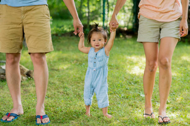 istock Baby Girl Learning to Walk with Help from her Parents 1481026726