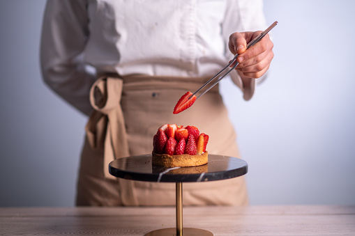 Female chef making a cake with strawberries
