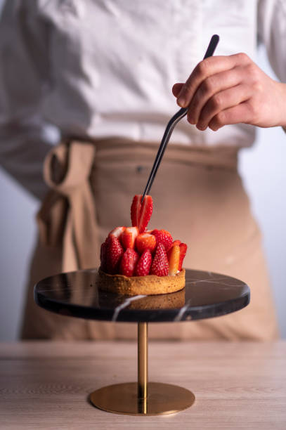 istock Female chef making a cake with strawberries 1481028926