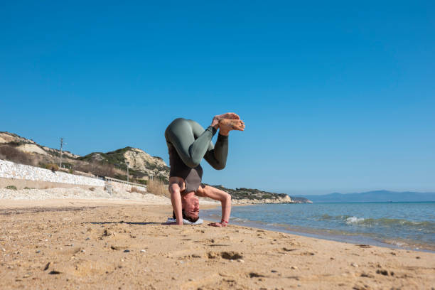 istock Woman practising yoga on the beach 1481029013