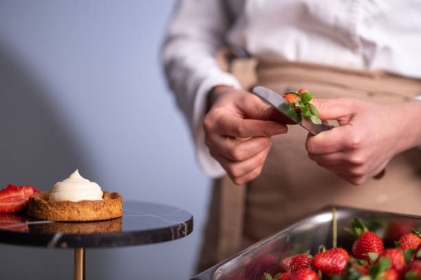 istock Female chef hands cutting strawberries for making cake 1481029084