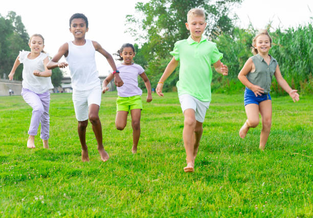 istock Five smiling kids running and laughing in park 1481030623