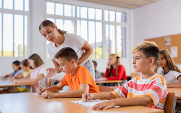 istock Group of preteen schoolchildren diligently making notes in class 1481031797
