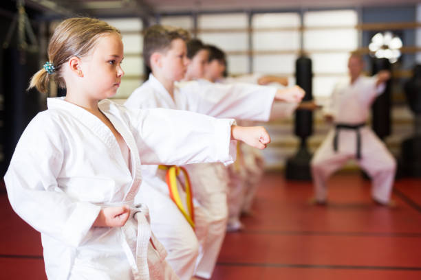 istock Children wearing karate uniform practicing new moves in group 1481032823