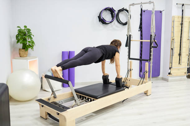 istock Strong woman doing control balance front exercise on Pilates reformer 1481036711