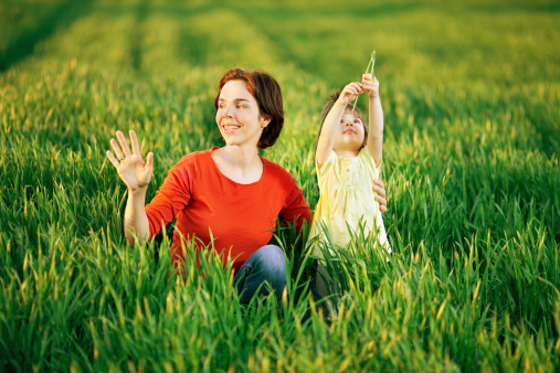 Beautiful young mother enjoying and having fun in a wheat field with her little daughter