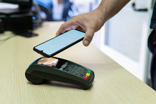 istock A man's hand paying with a contactless smartphone in a shop. 1481045572
