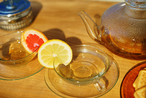 Tea cups with a slice of lemon and grapefruit on them.