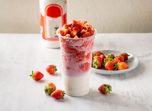 strawberry milk with raw fruits served in disposable glass isolated on background top view taiwan food