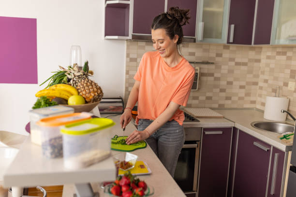 istock Young Woman Prepares Fresh Vegetarian Ingredients in Her Kitchen 1481054986