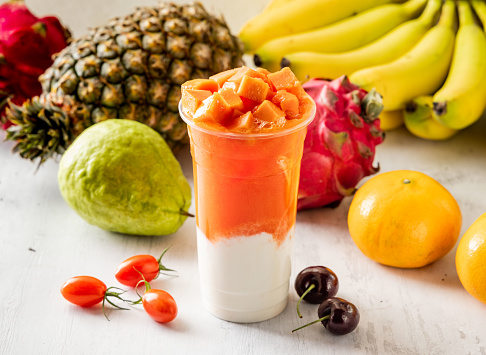 papaya milk with raw fruits served in disposable glass isolated on background top view taiwan food