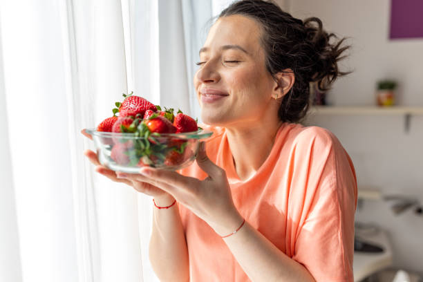 Woman Indulging in Delicious Strawberries for Dessert stock photo