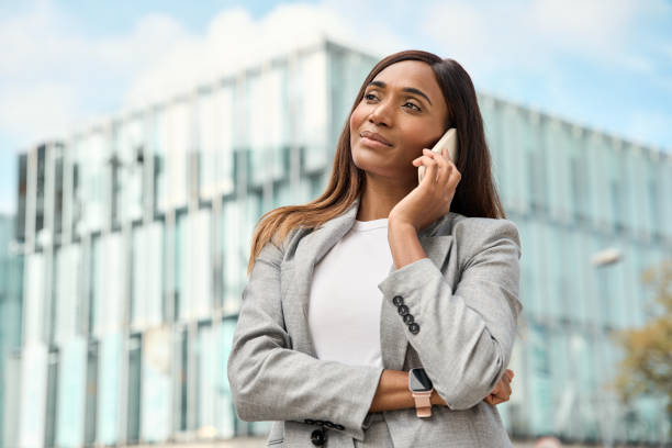 istock Middle age businesswoman talking on smartphone, standing at office center. 1481056449