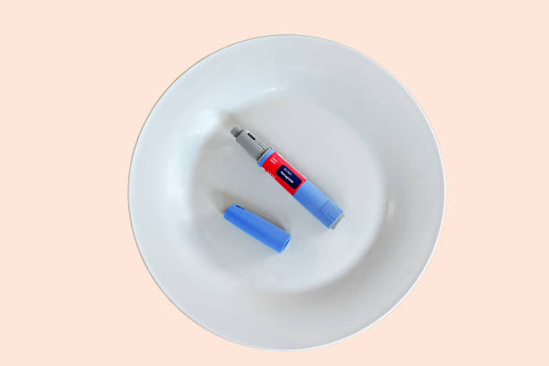Semaglutide pen Semaglutide injecting  pen with lid on a white plate wegovy stock pictures, royalty-free photos & images
