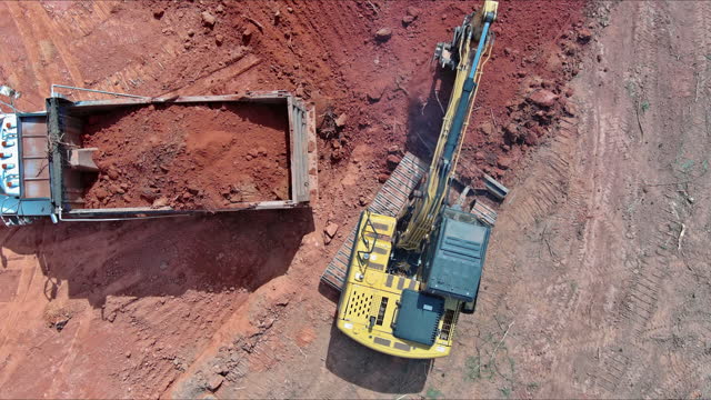 Loading earth into a dump truck on a construction site with an excavator