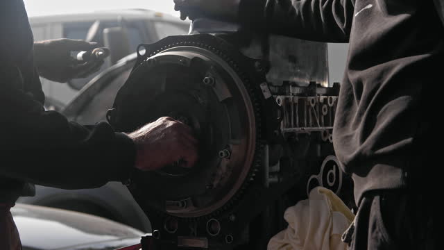 Tightening the Flywheel Gear of the Old Car Engine in the Repair Shop