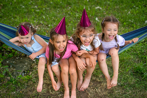 Two little girls enjoy a hug at a picnic in the park.