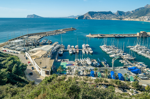 Calpe, Spain - January 27, 2022: View of the fishing port of Calpe from the Peñon de Ifach Natural Park, Alicante province, Valencian Community, Spain