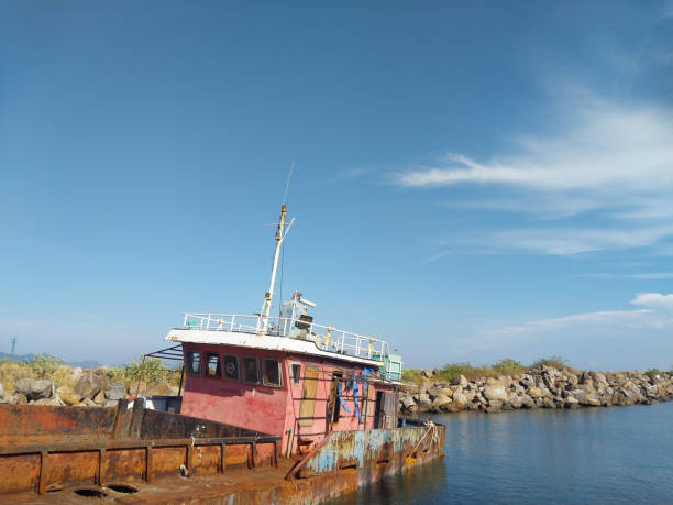 istock Abandoned Half-Sunken Ship with Calm Water and Beautiful Clouds 1481066727