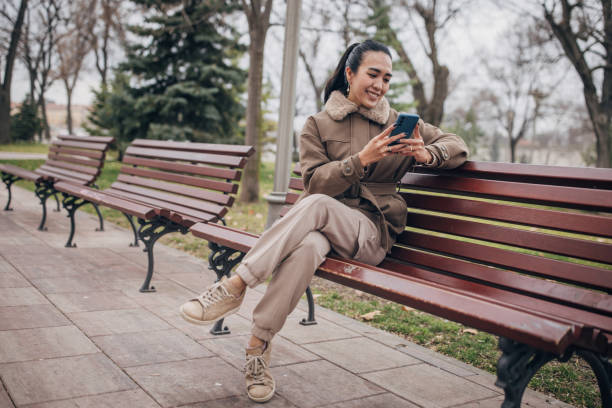 istock Woman sitting on bench in park 1481070887