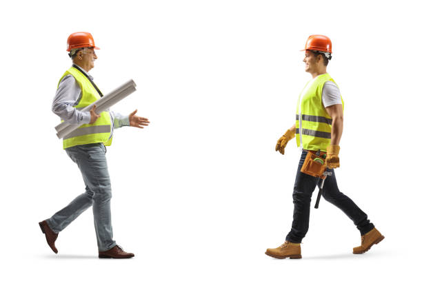 istock Full length profile shot of an engineer carrying blueprints and greeting a construction worker 1481074801