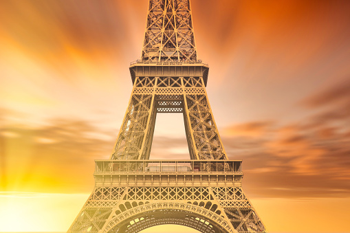 The Eiffel Tower in the Paris at sunset with bright lens flare.
