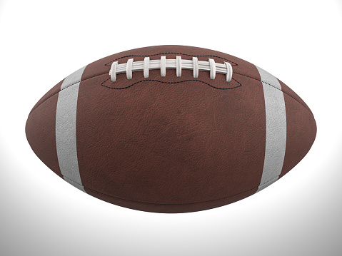 A low angle view of a leather American Football spotted next to a goal line within inches of a blue end zone.