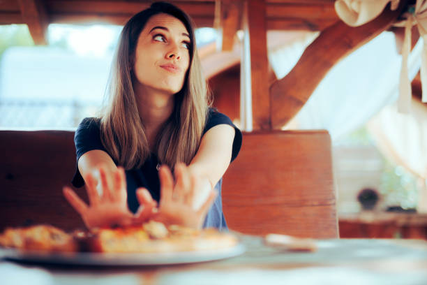 Unhappy Woman refusing to Eat her Pizza Dish in a Restaurant