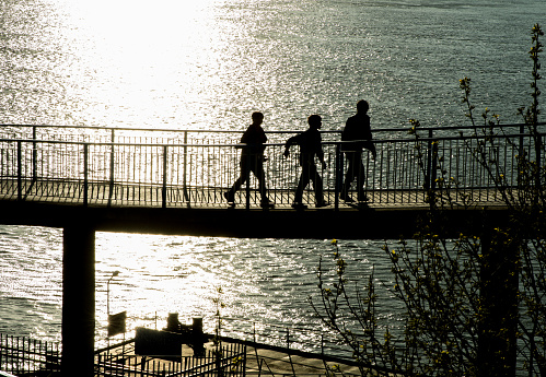 Ruse, Bulgaria, Danube river - 04.10.2017 
Kids having a walk on a bridge along the river in a spring morning.