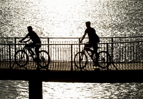 Ruse, Bulgaria, Danube river - 04.10.2017 
Kids with bicycles riding along a bridge close to the river.