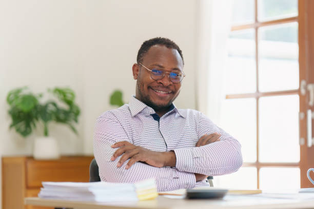 istock Smiling American African makes financial report and studies annual figures, analyzes profits. Accountant checks status of financial 1481106159