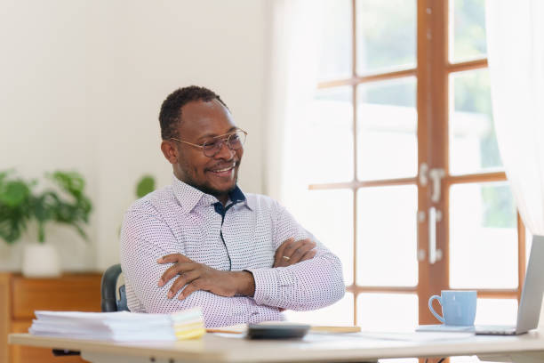 istock Smiling American African makes financial report and studies annual figures, analyzes profits. Accountant checks status of financial 1481106166