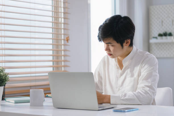 istock A young businessman is shown working on a laptop computer in his home office. The image represents the concept of working from home. 1481106219