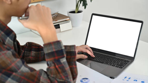 istock Cropped shot of young hipster male freelancer using laptop computer at white working desk. 1481109276