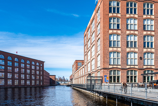 Tammerkoski River in Tampere Finland and old red brick factory buildings. Spring urban landscape.