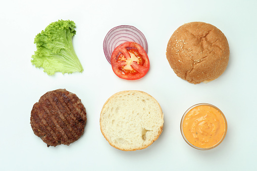 Two big homemade delicious cheesburger, with onion, grilled bacon, fresh tomatoes, cheese, and lettuce served on a wooden cutting board