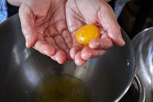 separating egg yolk with hand
