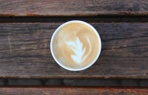 istock Cappuccino Cup With Flower Pattern On A Foam On A Wood Planks  Top View 1481119956