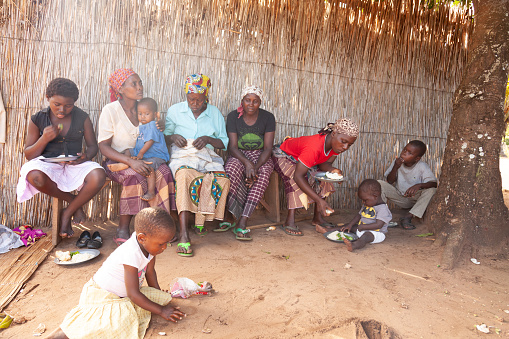Xai Xai, Mozambique, April, 2014: Mothers and older women feed the children lunch of steamed rice and vegetables in a poor village outside Xai Xai Mozambique