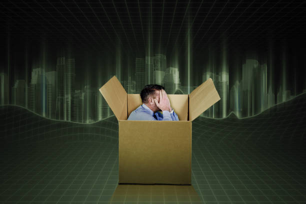 Male employee feeling sad inside a cardboard