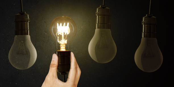 istock A man holds a luminous bulb in his hand with other off bulbs 1481120821
