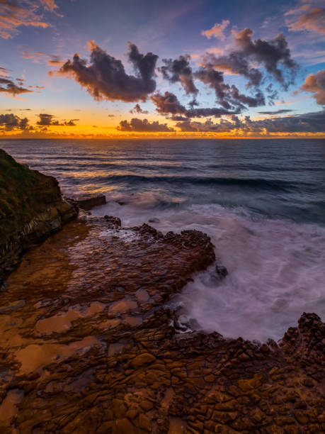 istock Sunrise and clouds over the ocean and rock platform 1481122299