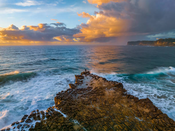 istock Sunrise and clouds over the ocean and rock platform 1481122410