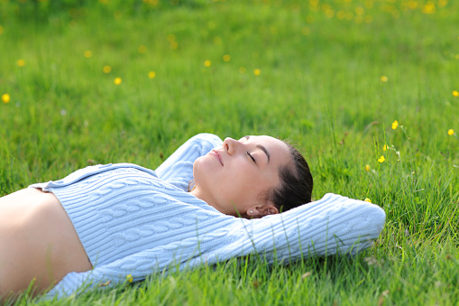 Casual woman relaxing lying on the grass