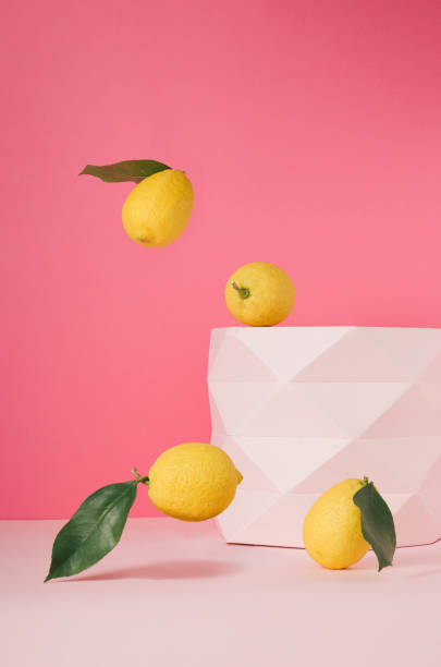 istock Lemons with green leaves against a pastel pink background. The design features a vertical frame. 1481124220