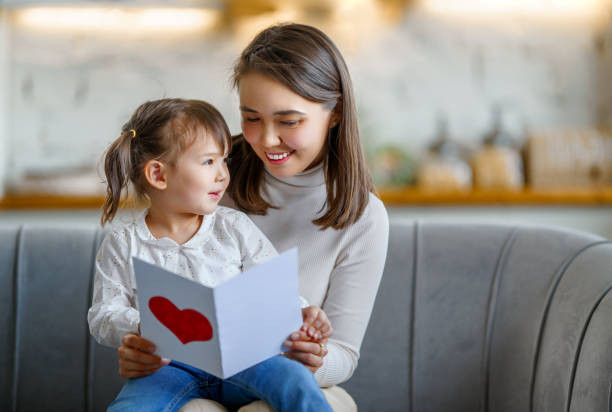 istock Daughter giving mother postcard 1481126953