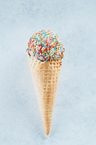 Ice cream cones with sprinkles. Summer Dessert ice-cream, yummy delicious treat. Top view, copy space. Blue background