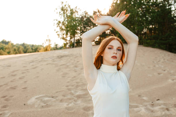 istock Redhead woman with raised arms on sandy beach 1481136031