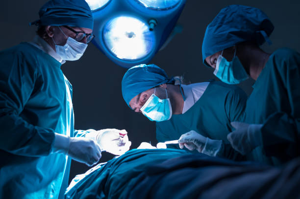 group of concentrated surgical doctor team doing surgery patients in hospital operating theater. professional medical team doing critical operations. - surgeon urgency expertise emergency services imagens e fotografias de stock