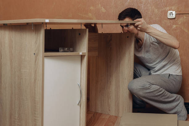 istock Man assembling new wooden desk at home 1481136624